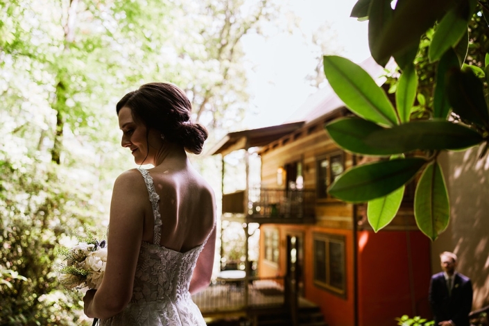 Bride portrait at North Carolina mountain wedding venue with rustic cabin backdrop.