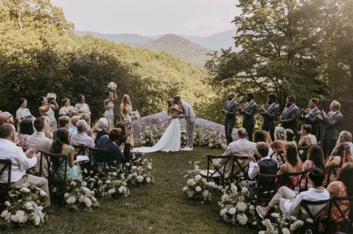 Bride and groom sharing their first kiss during an outdoor mountain ceremony at Laurel Falls