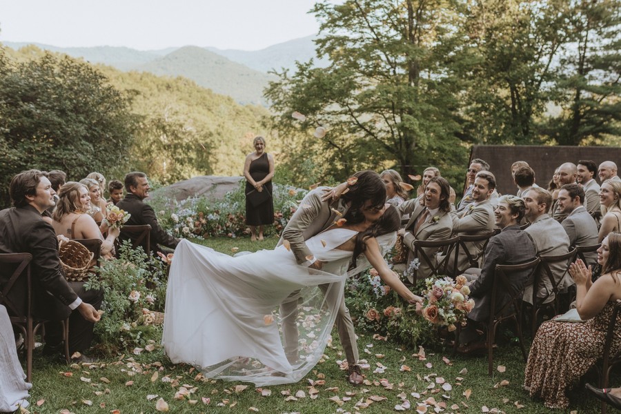Newly married couple sharing a kiss during their outdoor wedding ceremony at Laurel Falls