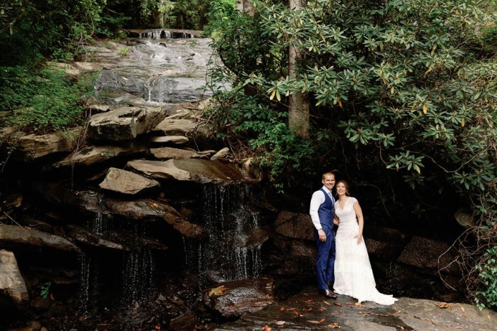Bride and groom standing together at the waterfall at Laurel Falls wedding venue