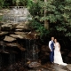Bride and groom standing together at the waterfall at Laurel Falls wedding venue