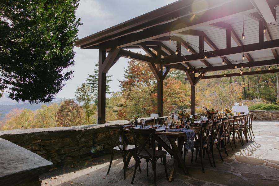 Outdoor reception tables under The Lodge Porch at Laurel Falls wedding venue and fall mountain views in the background