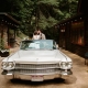 Bride and groom sit in a vintage car in the Italian Grotto at Laurel Falls