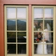 Bride and groom seen through cabin window at Laurel Falls with mountain reflection